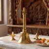 Bell_on_white_marble_platform_202607091701 Handcrafted Pure Brass Ganesha Pooja Hand Bell (12 cm / 4.72 Inches) – Traditional Carved Brass Ghanti with Lord Ganesha Finial Handle