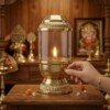 Brass_diya_rotating_wick_adjuster_202607121306 Handcrafted Vintage Lantern Style Pure Brass Akhand Diya with Cylindrical Glass Chimney & Fluted Brass Crown Lid