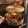 ChatGPT Image Jul 23, 2026, 10_48_23 PM Handcrafted Pure Brass Masala Dabba (Masaliyu) – Royal Spice Box Set with 7 Inner Cups, Engraved Lid & Brushed Matte Gold Finish